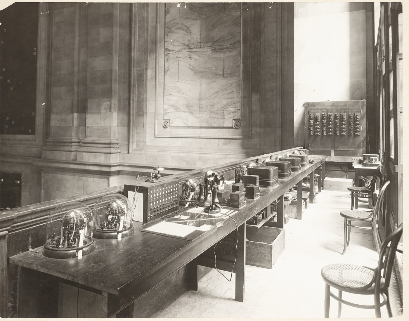 The central control station of the New York Stock Exchange ticker, 1922: rows of printing telegraphs under glass on long tables